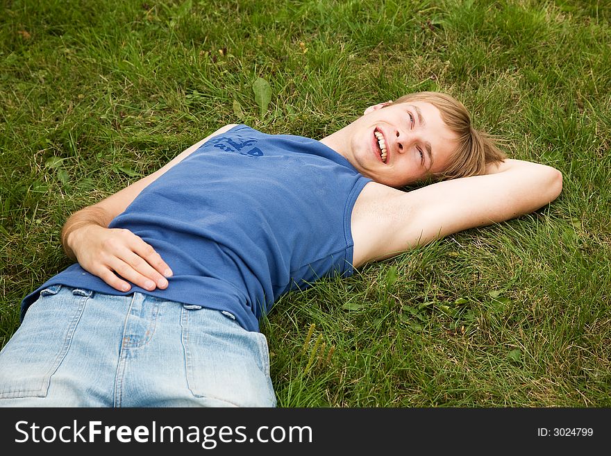 Smiling boy lying on the green grass