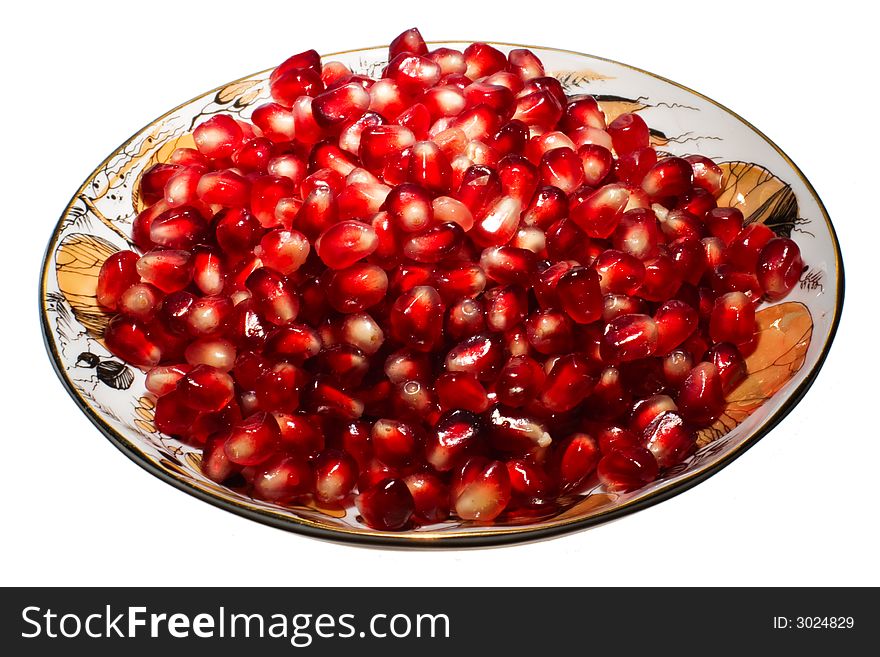 Pomegranate grains on a plate.  Isolated on white.