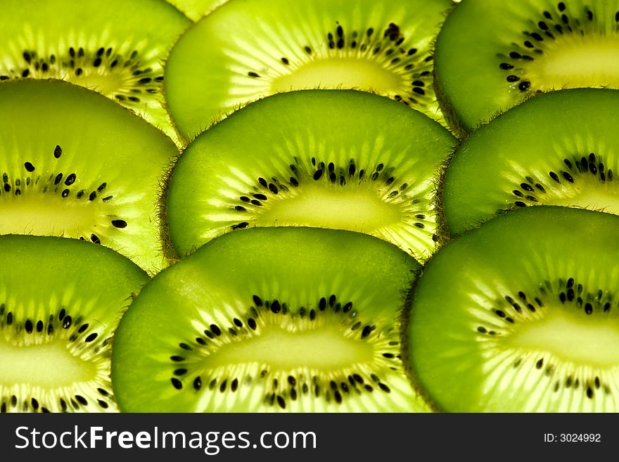Glowing slices of kiwi highlited from below. Glowing slices of kiwi highlited from below