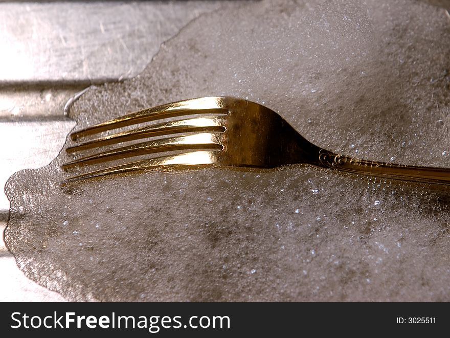 Set of Cutlery gold in color on a sink top. Set of Cutlery gold in color on a sink top