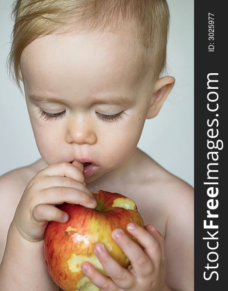 Image of cute toddler eating an apple. Image of cute toddler eating an apple