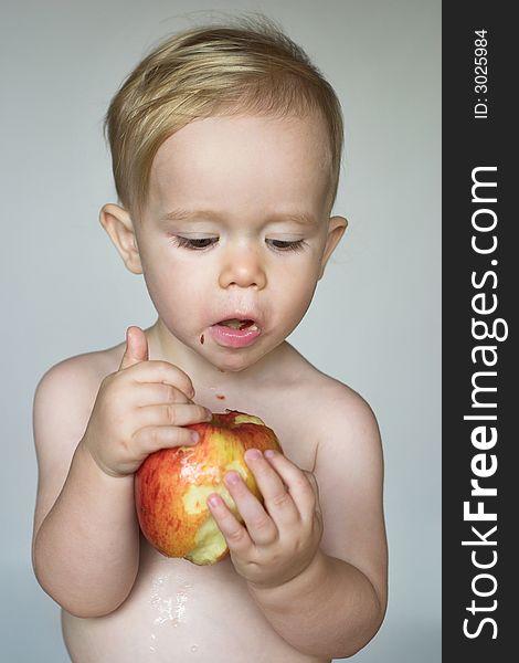 Image of cute toddler eating an apple. Image of cute toddler eating an apple
