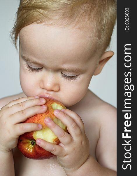 Image of cute toddler eating an apple. Image of cute toddler eating an apple