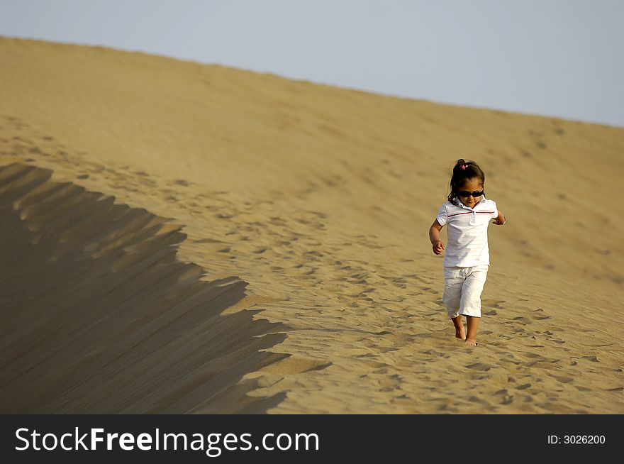 A child is walking alone in the desert. A child is walking alone in the desert