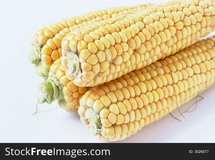 Four yellow cob corn on white background