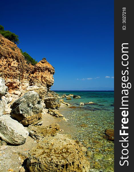 Sandy coast with rocks and blue sky