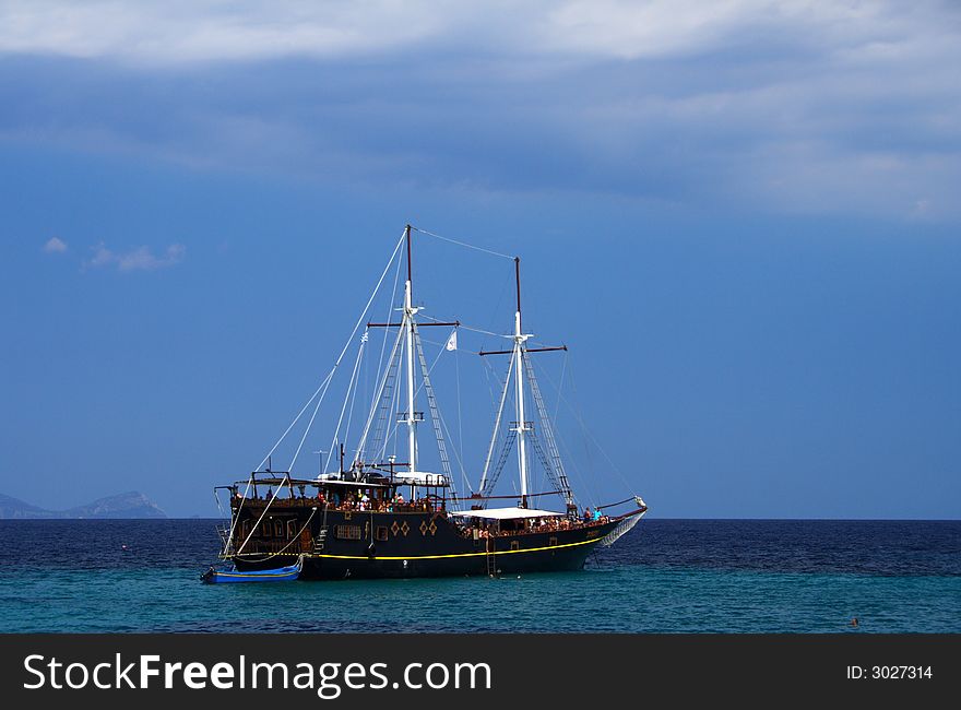 Old sailboat with tourists in the blue