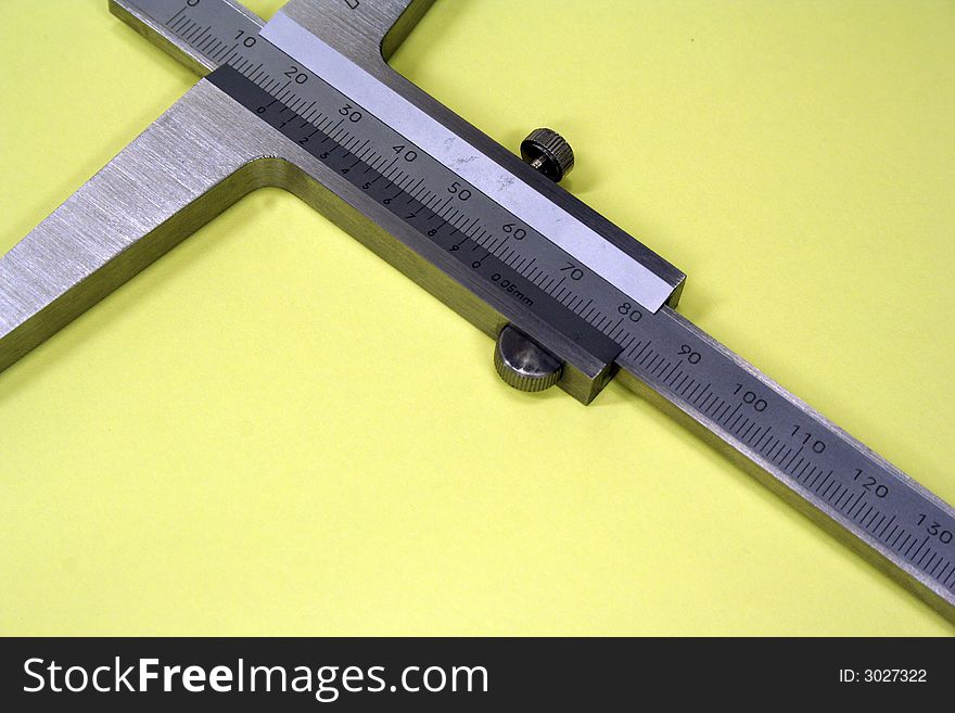 Caliper isolated against yellow background metal