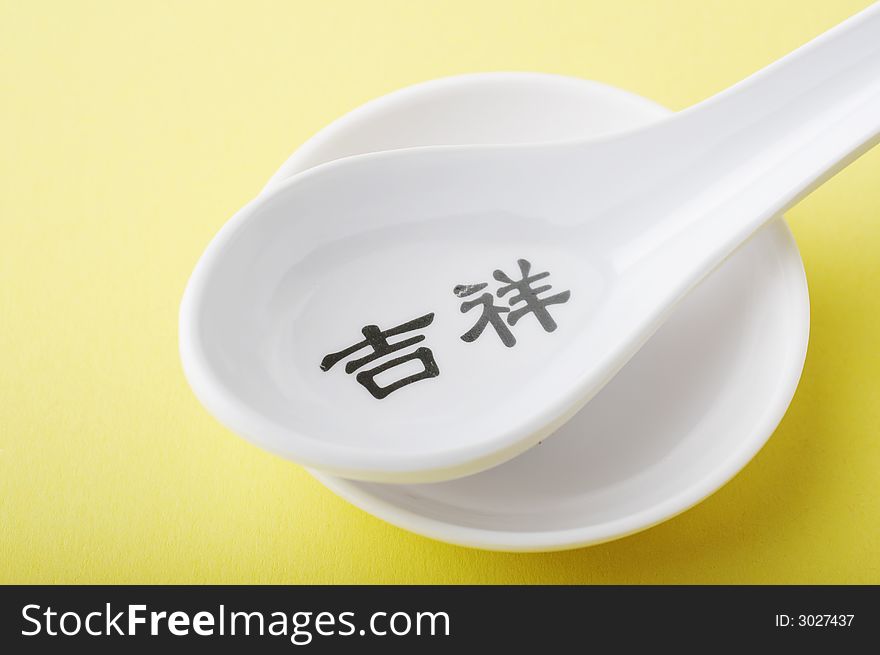 Asian style plastic spoon over a yellow background
