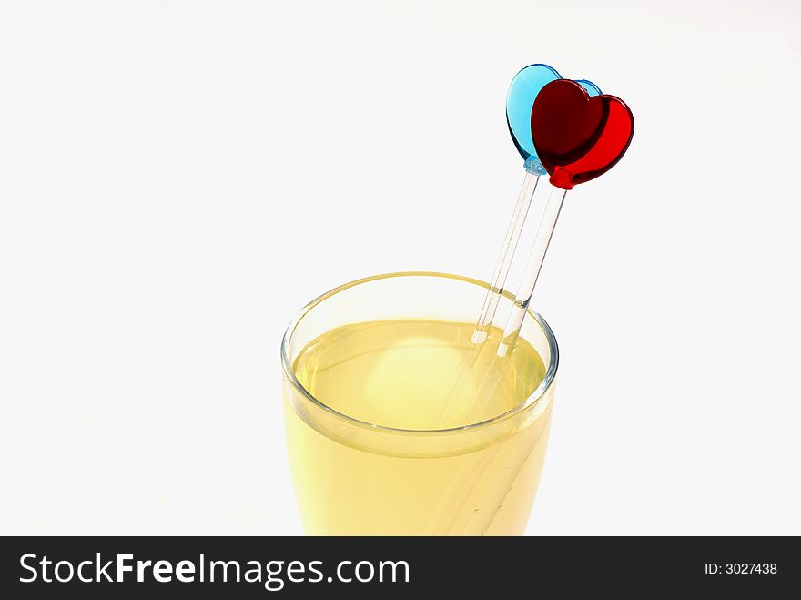 Isolated glass of juice with heart shaped sticks. Isolated glass of juice with heart shaped sticks.