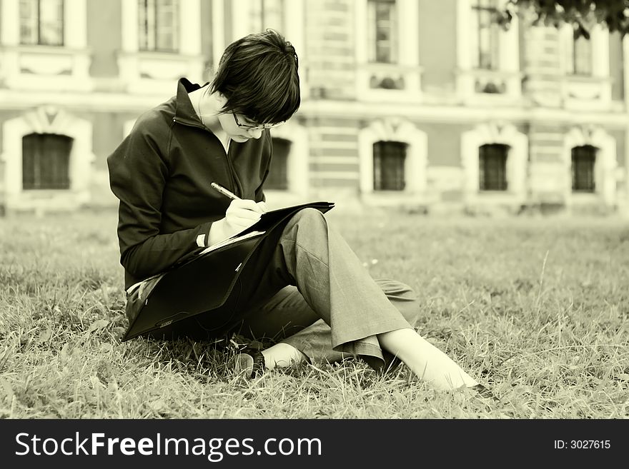 Student girl. Studying at grass. Toned.