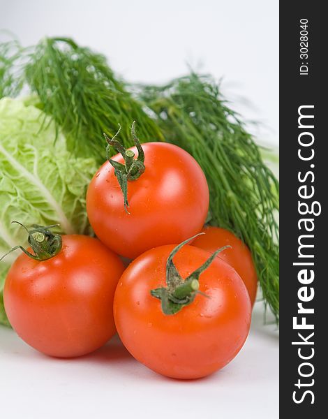 Pile of tomatoes with lettuce and dill on the background