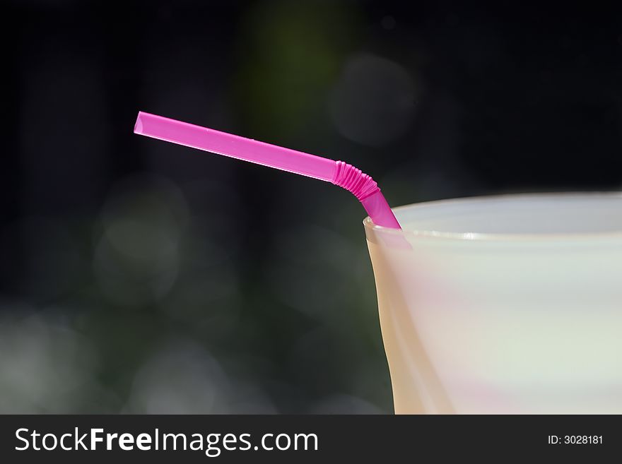Close-up of a pink bendable straw in a yellow cup. Close-up of a pink bendable straw in a yellow cup.
