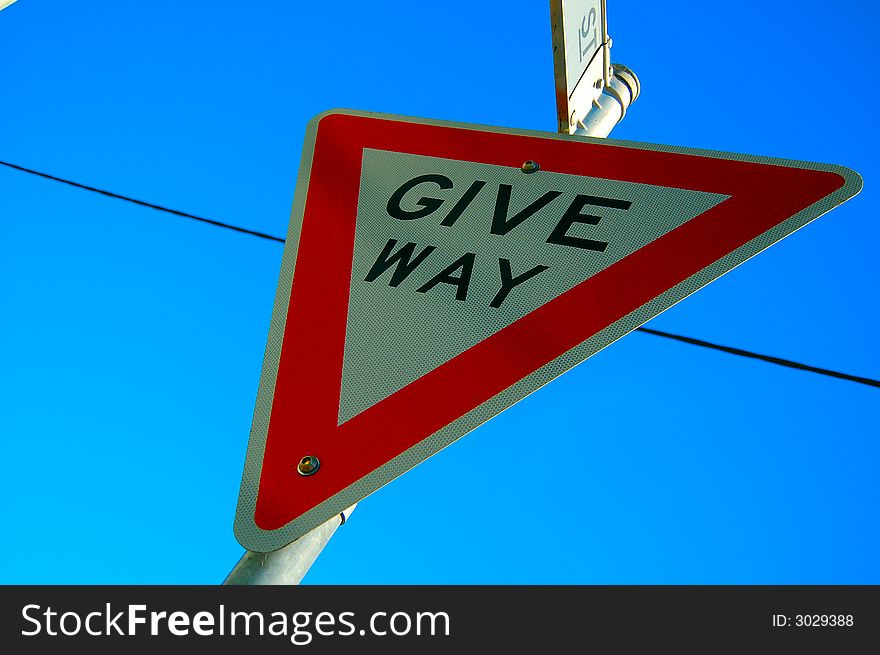 Give way sign on a clear blue sky day