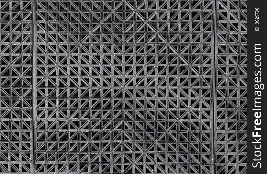 The symmetrical pattern of a textured rubber mat.