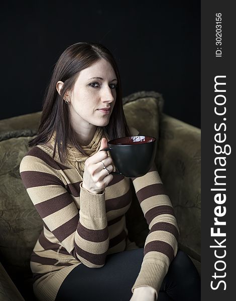 Beautiful young woman with brown hair and eyes holding a black coffee cup. Beautiful young woman with brown hair and eyes holding a black coffee cup.