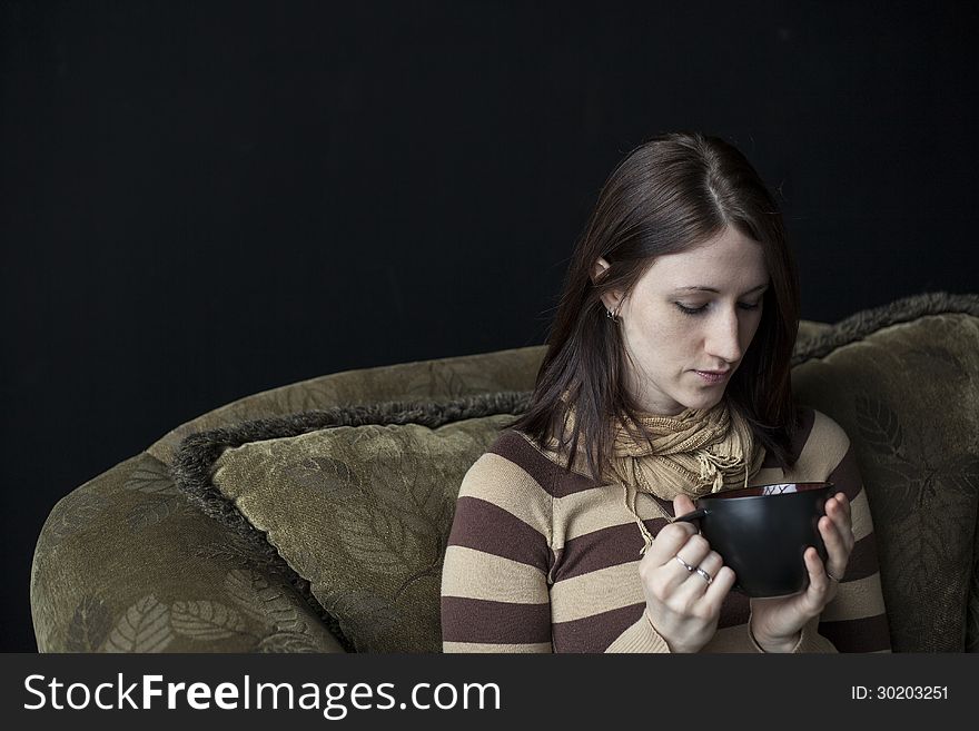 Beautiful young woman with brown hair and eyes holding a black coffee cup. Beautiful young woman with brown hair and eyes holding a black coffee cup.