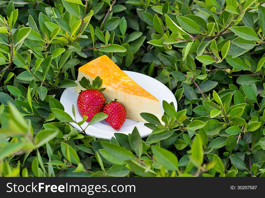Yellow cake souffle with strawberry on the green grass