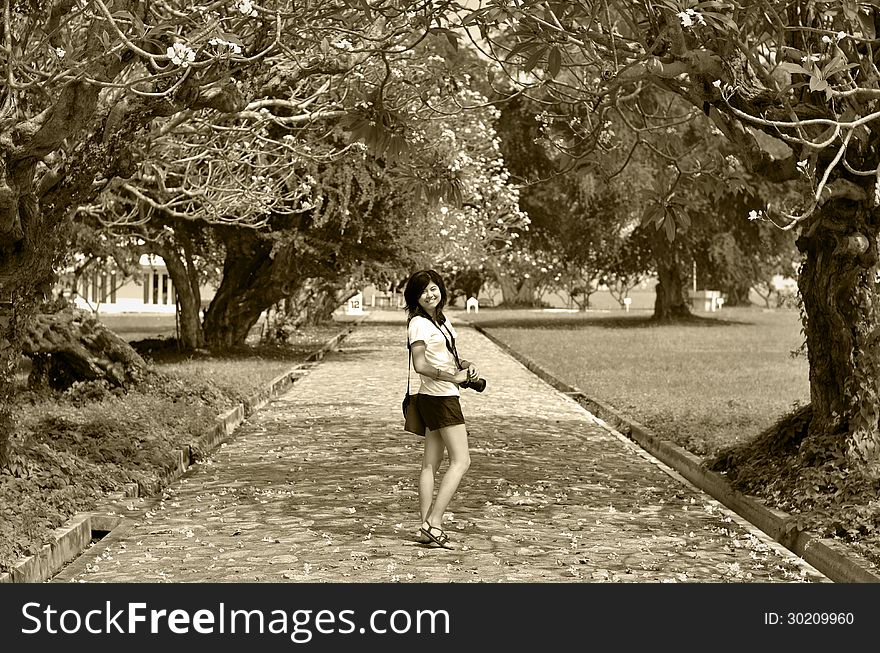 Portrait of sweet young woman standing outdoors and smiling against beautiful nature