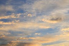 Beautiful Cirrus And Small Cumulus Clouds Of Yellow And Orange Colors In The Blue Sky Illuminated By The Morning Sun Rays Royalty Free Stock Photos