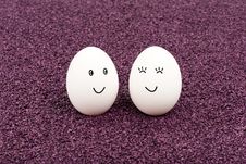 Two Smiling Eggs On Purple Sand. Royalty Free Stock Images