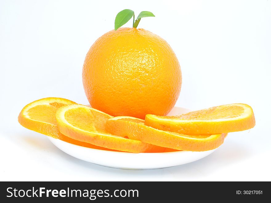 Orange and orange pieces on a plate and white background. Orange and orange pieces on a plate and white background