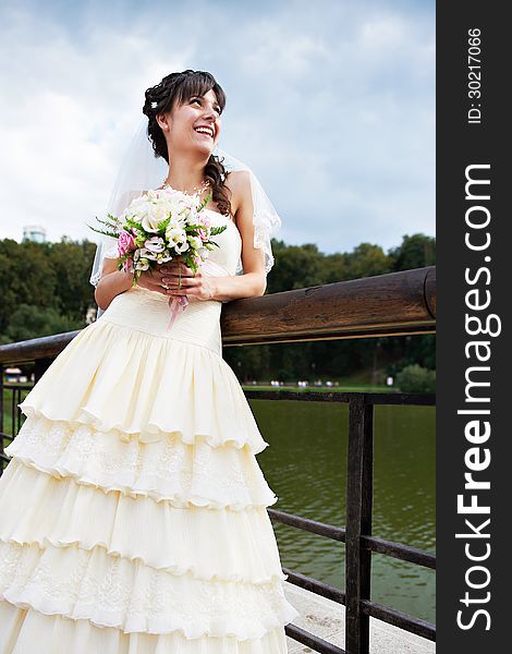 Happy bride about lake in summer day
