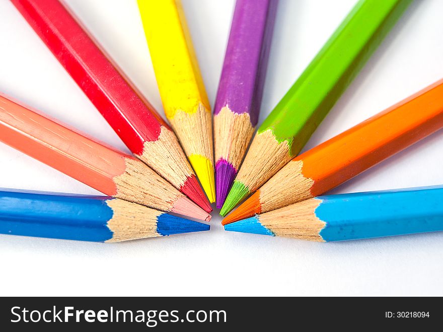 Seven color pencils point to each others