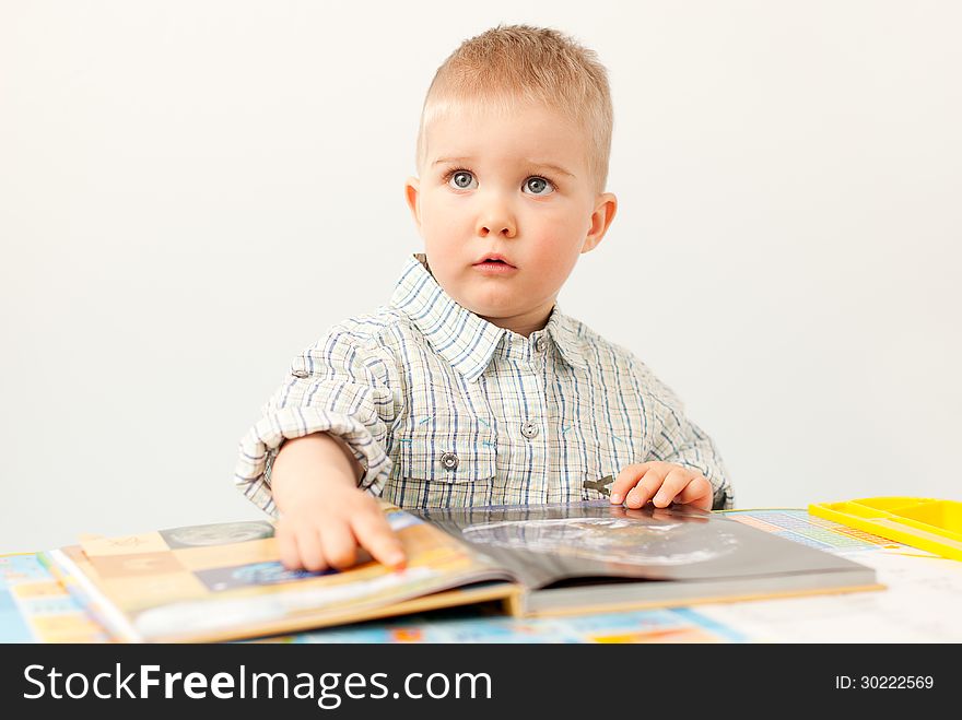 curious baby boy studying with the book