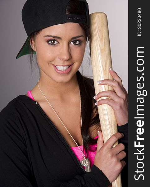 Pretty Female Baseball Lover Holds A Wooden Bat And Smiles