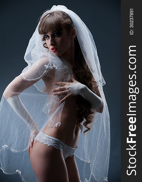 Portrait of sexy girl in veil and panties showing shapely beautiful body in the studio. Portrait of sexy girl in veil and panties showing shapely beautiful body in the studio