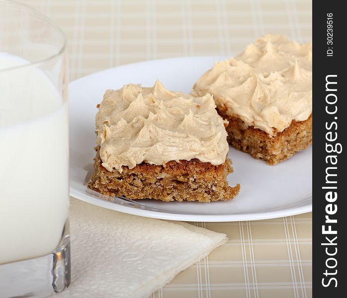Two peanut butter bars on a plate with a glass of milk. Two peanut butter bars on a plate with a glass of milk