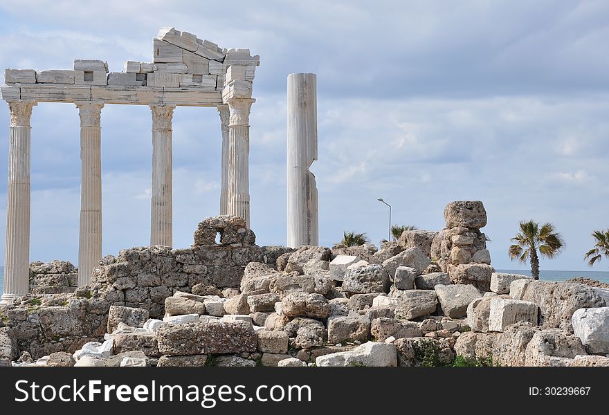 Image shows the Apollo-Temple of Side, Turkey. In the front some small stones, some ruins in the middle. Sky is cloudy. Image shows the Apollo-Temple of Side, Turkey. In the front some small stones, some ruins in the middle. Sky is cloudy.