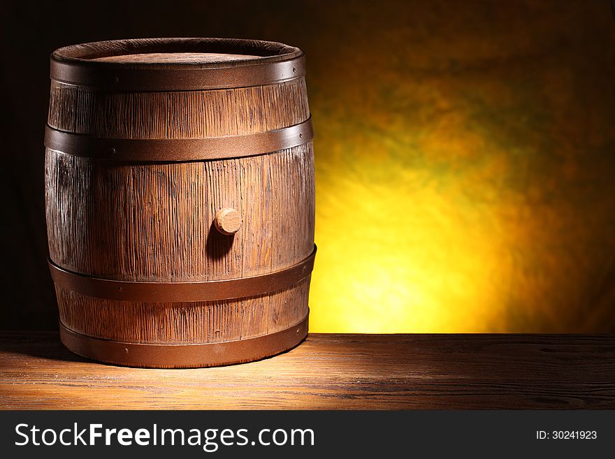 Wooden barrel on a dark yellow background. Wooden barrel on a dark yellow background.