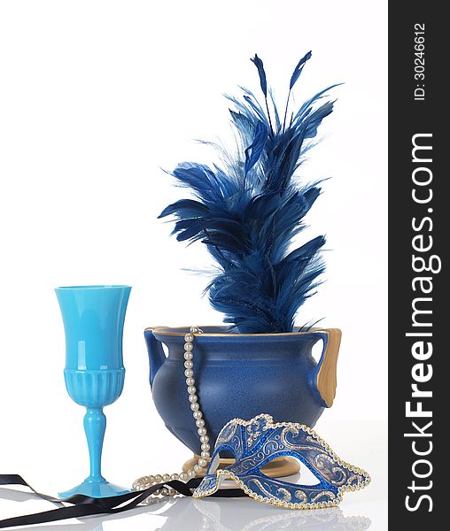 Photo of a blue mask with vase, feather, wine cup, and feathers.