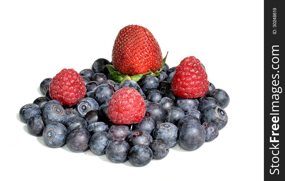 Strawberry and three raspberries sitting on a group of blueberries. Strawberry and three raspberries sitting on a group of blueberries.