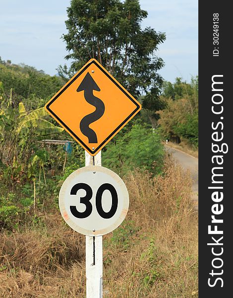 Zig Zag road warning sign and 30km limit speed limit sign in country side