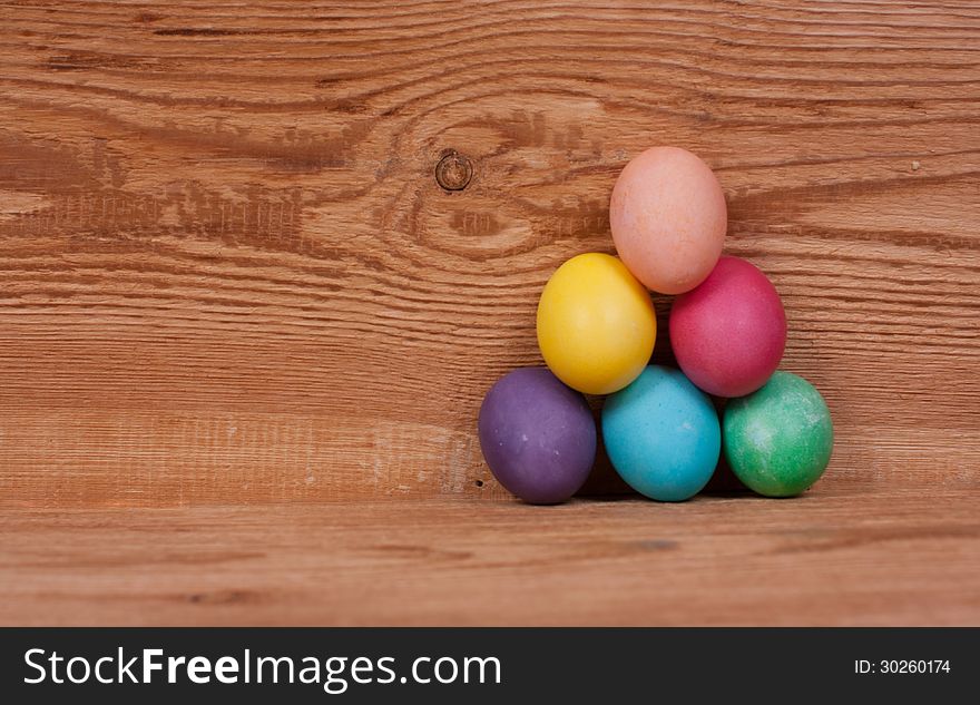 Pyramid on a wooden background of colored eggs for Easter. Pyramid on a wooden background of colored eggs for Easter