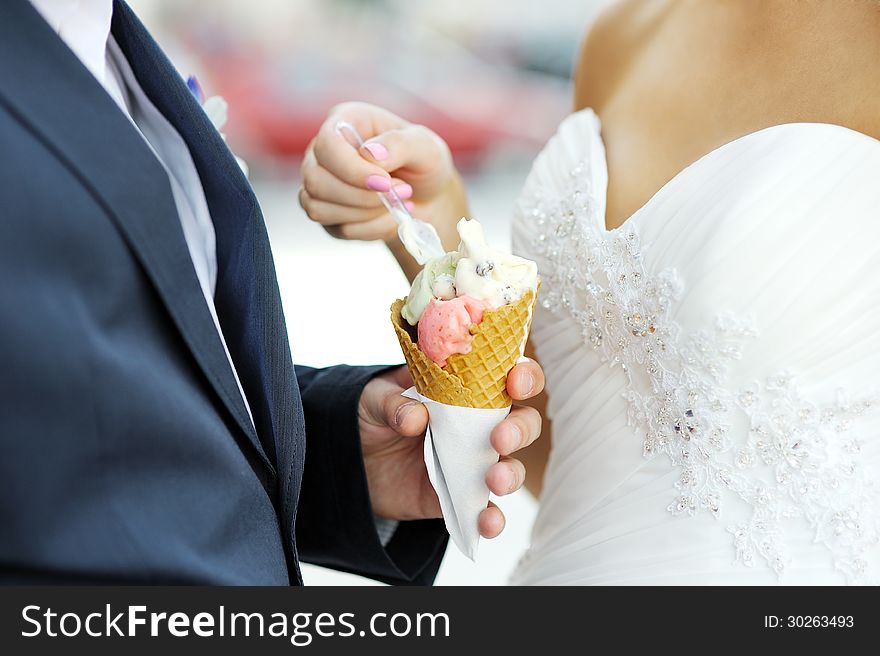 Bride with an ice-cream which is in the hand of the groom