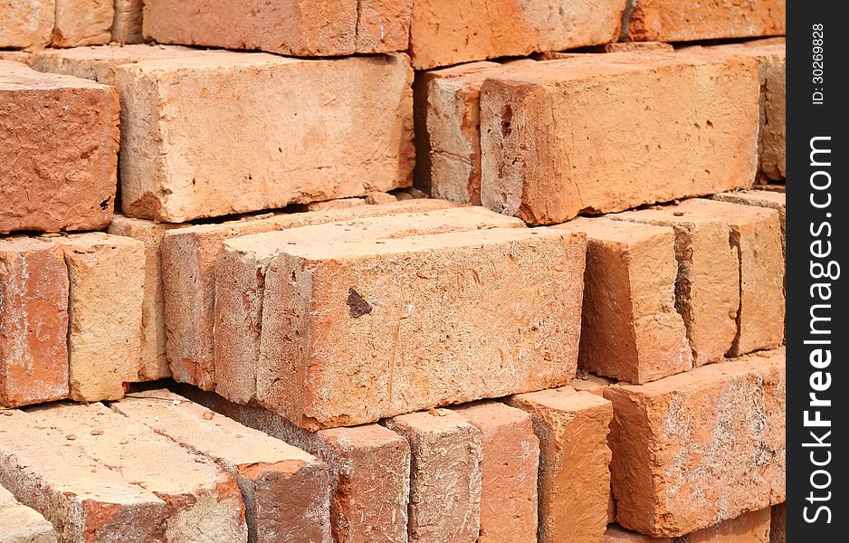 Stack of red clay bricks in warehouse
