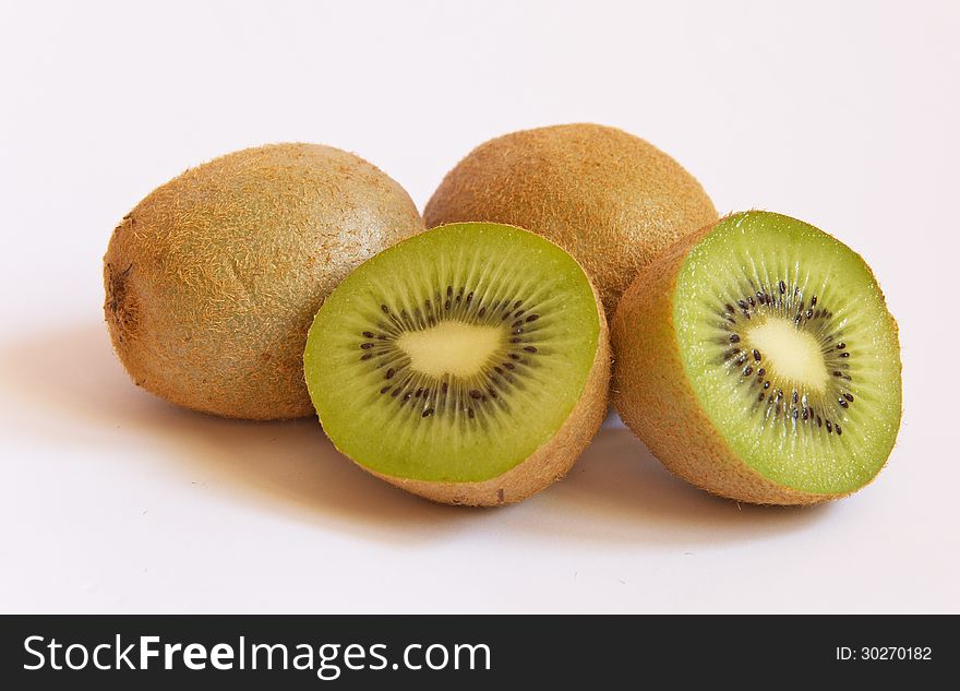 Cut kiwi fruits laying on white background