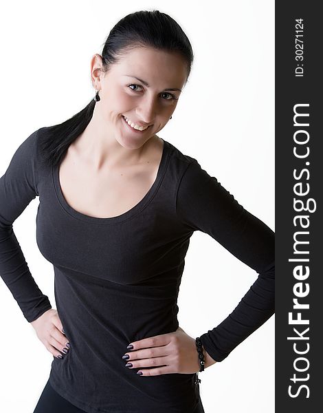 Portrait of young woman in black standing with arms on hips, looking playfully with sweet smile. Shot in studio. Isolated on white. Portrait of young woman in black standing with arms on hips, looking playfully with sweet smile. Shot in studio. Isolated on white.