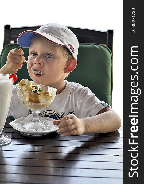 Boy in a baseball cap on a white background,boy eating ice cream. Boy in a baseball cap on a white background,boy eating ice cream
