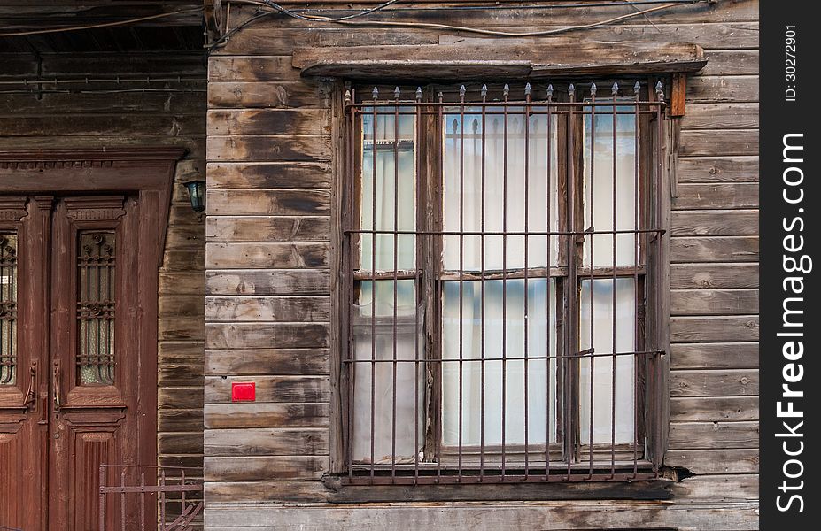 Horizontal photo of a wooden building window and door. There is a blank number plate. The wood walls are raw and unpainted. Horizontal photo of a wooden building window and door. There is a blank number plate. The wood walls are raw and unpainted.