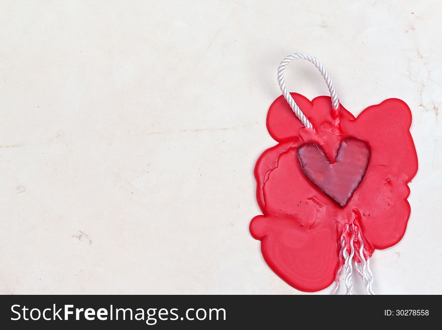 Mark in the shape of a heart made of red wax on the background of old paper. Mark in the shape of a heart made of red wax on the background of old paper