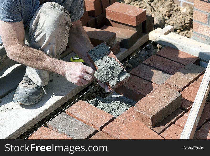 Brick Mason Applying Mortar.