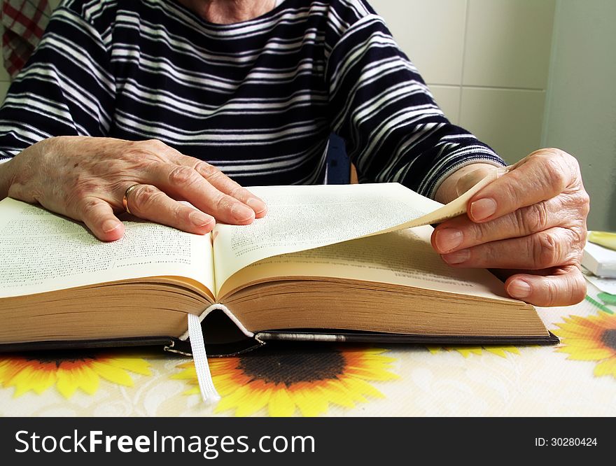 Close-up of the hands of senior woman with a book. Close-up of the hands of senior woman with a book.