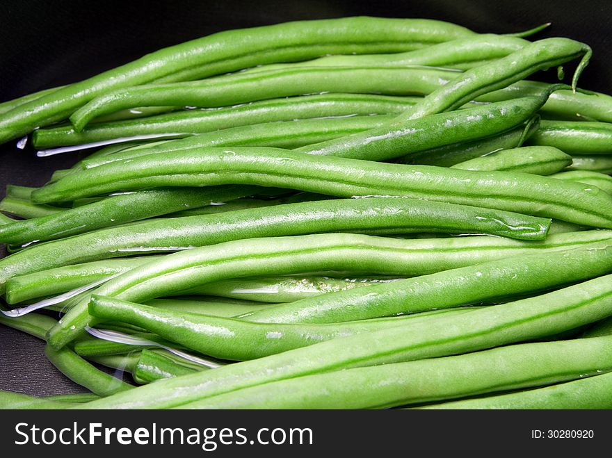 Boiling green beans in a black pan. Boiling green beans in a black pan