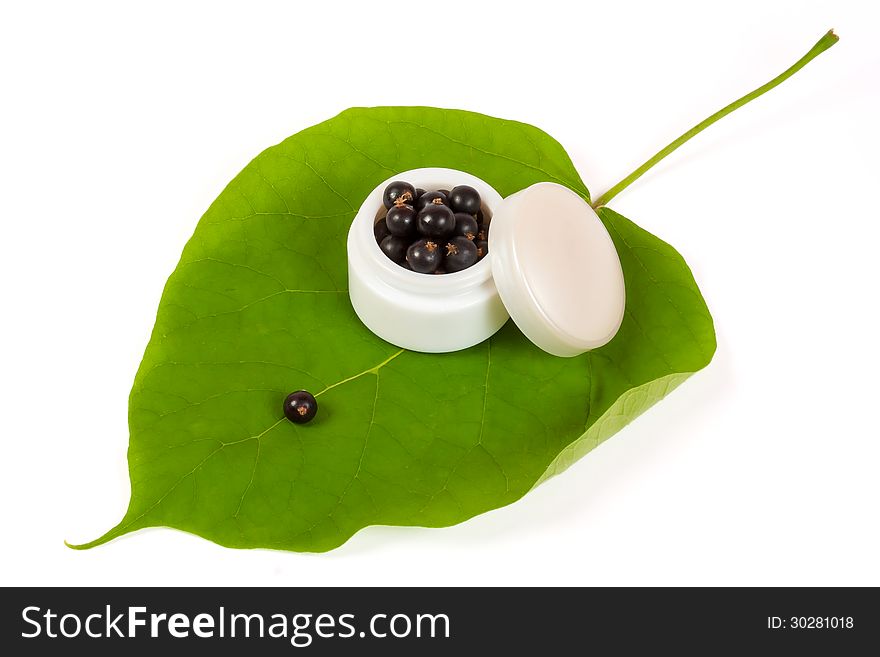 Black currants in a jar of makeup on the big green leaf. Black currants in a jar of makeup on the big green leaf