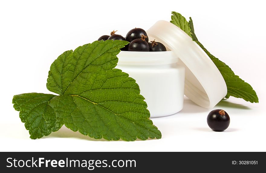 Black currants in a jar of makeup with green leaves. Black currants in a jar of makeup with green leaves